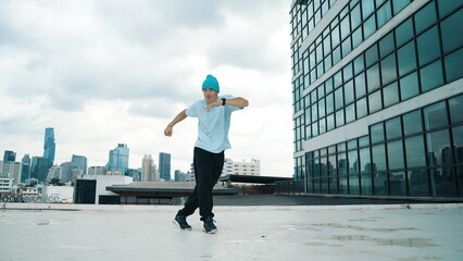 Stylish caucasian dancing man performing break dance at skyscraper. Portrait image of young happy...
