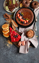 Tasty cake, cookies, waffles, macaroons, muffin. Delicious desserts on dark background. Food concept