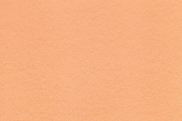 Color of the year 2024 peach fuzz. Texture of coral colors paper background, macro. Structure of craft cardboard.