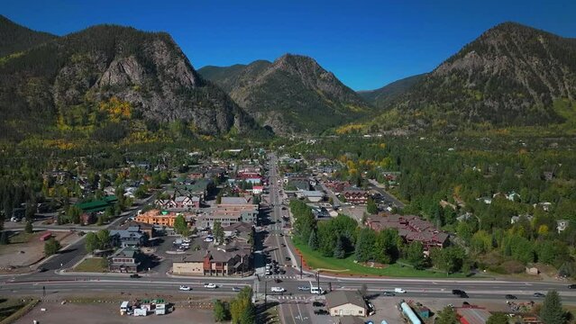 Downtown Frisco Colorado aerial cinematic drone traffic Main Street early yellow fall colors Aspen trees morning Lake Dillon Keystone Breckenridge Silverthorne Ten Mile Range blue sky pan up motion