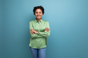 young pretty latin business lady in green shirt posing on blue background with copy space