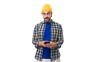 young brutal brunette man with a beard and mustache chatting on a mobile phone in social networks