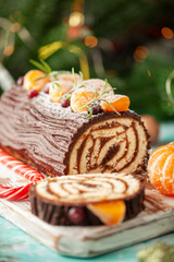 Yule log roll cake with chocolate ganache  on Christmas decorated background