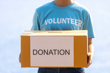 Volunteer people is holding box of money raising donation in the charity work and ngo related...