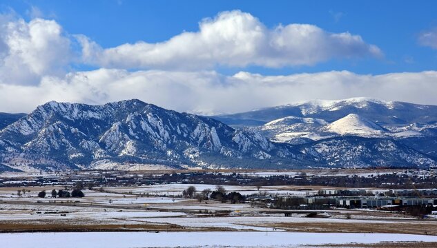 the  striking boulder flatirons and  snow -capped peaks of the front range of the colorado rocky mountains in winter as seen from broomfield, colorado