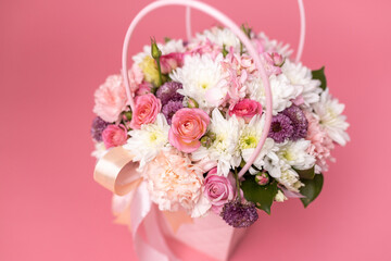 Beautiful bouquet of flowers on a pink background. Gift for holiday, birthday, Wedding, Mother's Day, Valentine's day, Women's Day. Floral arrangement in a hat box