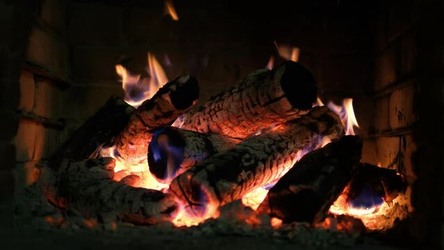 A fireplace with burning logs. Fire in the fireplace. A cozy place to rest. Fire and firewood as background. Burning wood in the furnace. Fire video