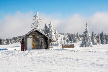 wooden alpine house covered with snow, ski slope