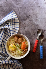 bowl of seafood noodles with egg on grey background
