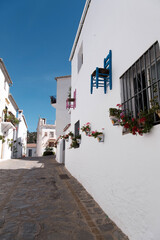 street in the town, Parauta, Malaga, pueblo blanco con sillas colgadas de las fachadas, calle sin personas, tranquilidad y turismo rural