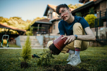 A man tends to his plants, surrounded by the tranquility of his house yard