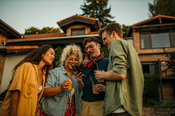 Diverse friends enjoy backyard vibes: laughing, chatting, and sipping drinks at a lively party
