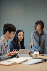 Fototapeta premium A successful senior female CEO is in the meeting with her team, coaching and briefing a new project.