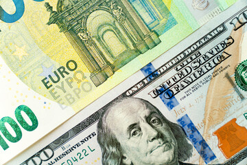Euro and dollar notes. euro against dollar. A closer look of the president of the USA with a dollar bill, peeping out from behind a euro bill. USA and Europe finance relation. Close up top view.