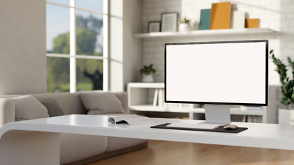 A computer with a white-screen mockup is on a white desk in a modern living room. Home workspace