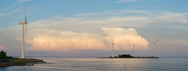 Renewable wind power generation on a wind farm by the sea with dramatic clouds on the background, Northern Finland