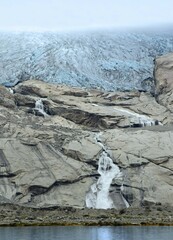 Obraz premium the sermeq glacie and waterfall at the end of the tasermuit fjord on a summer day near nanortalik, in southern greenland