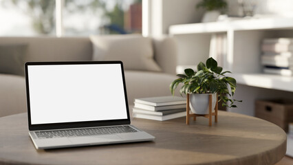 A white-screen laptop mockup on a wooden coffee table in a modern bright living room.