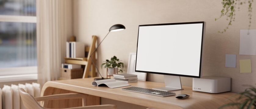A white-screen desktop PC computer mockup on a modern wooden desk and decor in a minimalist room.