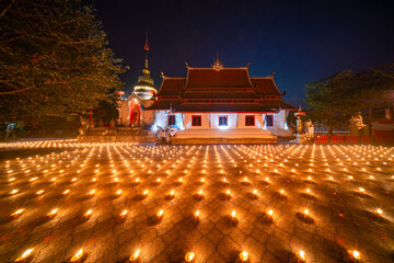 candles ligt around it in a temple. Candles burning around in area of front of chapel or church....