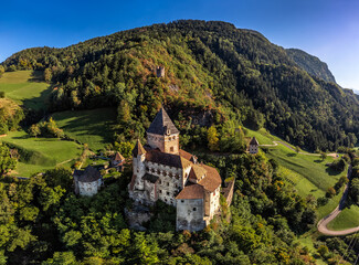 Val Isarco, Italy - Aerial panoramic view of Trostburg Castle (Castel Trostburg), a XII century fortress at the Italian Dolomites on a sunny summer day with green foliage and blue sky