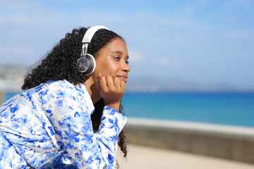 Black woman listening audio on the beach