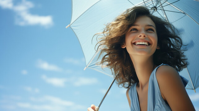 Happy woman with sunny blue sky holding a blue umbrella or sunshade to protect her skin from sun light with return of warm days