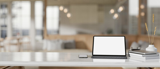 A white-screen digital tablet mockup on a white tabletop in a modern beautiful coffee shop.