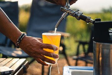 Beer on the table and camping party,hands toasting in beer,