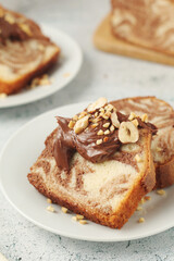 A piece of marble biscuit with chocolate cream and nuts