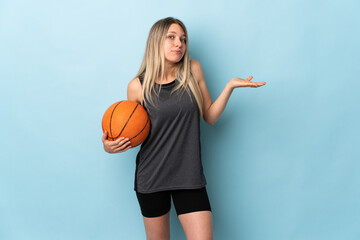 Young blonde woman playing basketball isolated on blue background having doubts with confuse face...