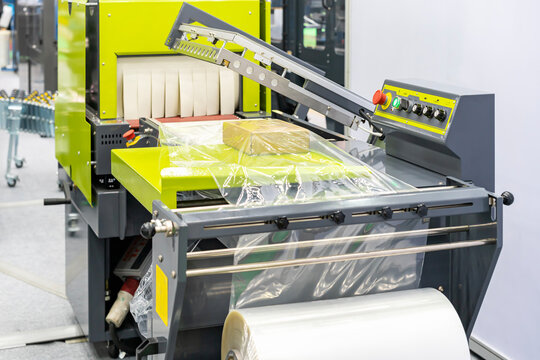 Cardboard box on table with plastic film of plastic film shrink packing machine for industrial