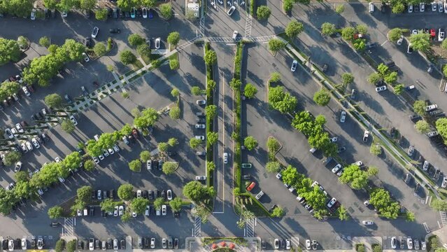 Top view of cars parking The Commons shopping center at Calabasas 101 highway, Los Angeles, USA. Aerial view of automobiles moving on the street with green trees. Transportation concept, 4k footage