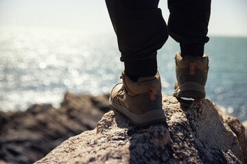 hiker legs stand on seaside rock