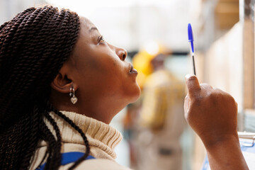 African american warehouse manager looking upwards and pointing with pen. Storehouse woman...