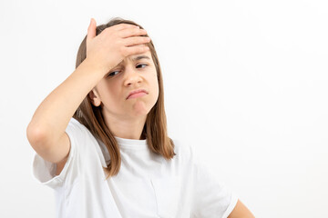 Sad girl touches her forehead with her hand, disappointment and despair.