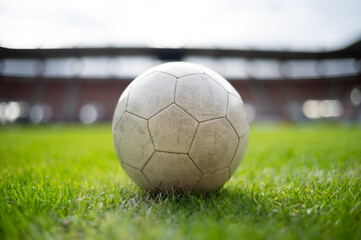 White soccer ball lying on the grass at stadium