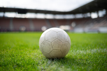 White soccer ball lying on the grass at stadium