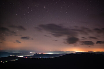 City lights seen from above. Light pollution covering the night sky. Amazing view with the...