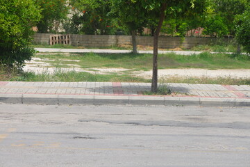 A section of an asphalt road with a curb stone and a lawn, minimalism, urbanism.