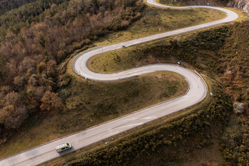 a camper van on a mountain road with many curves, ideal scenery.