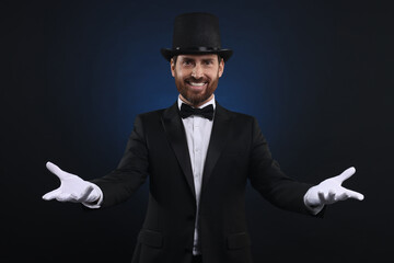 Happy magician in top hat on dark blue background