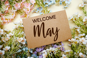 Welcome May text message with flower decoration on yellow background