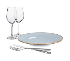 Clean plate, cutlery and glasses on white background