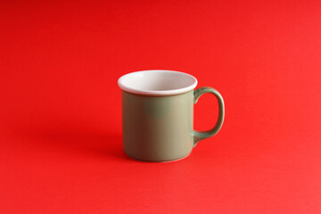 Green mug on an isolated red background, new year and christmas theme