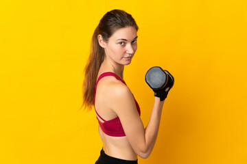Young Ireland woman isolated on yellow background making weightlifting