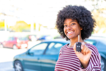 Fototapeta premium African American girl holding car keys at outdoors with happy expression