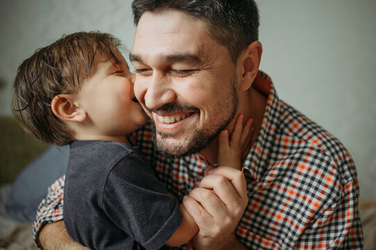 Happy father embracing cute son at home