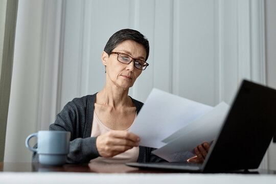 Adult Woman Working On Report Sitting In Front Of Laptop