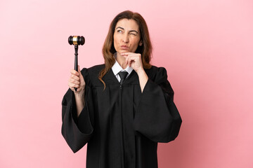 Middle aged judge woman isolated on pink background having doubts and thinking